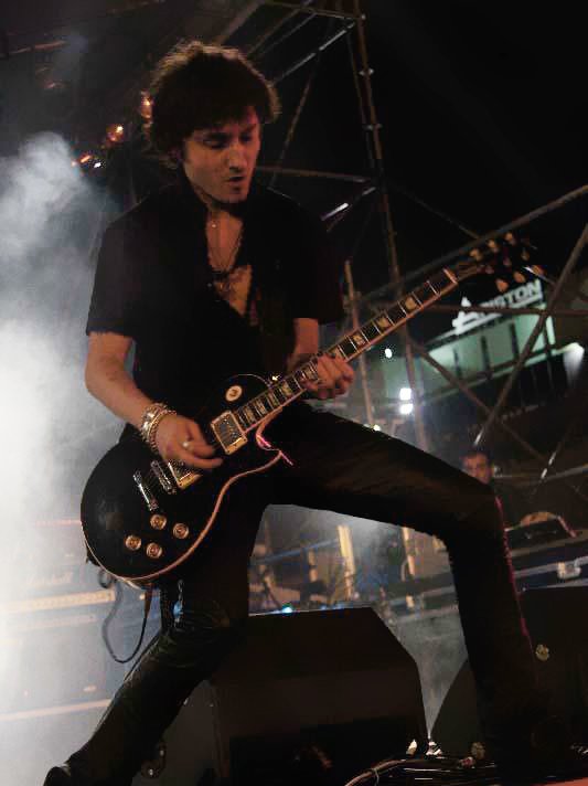 Marco Valeriani on stage playing the guitar
